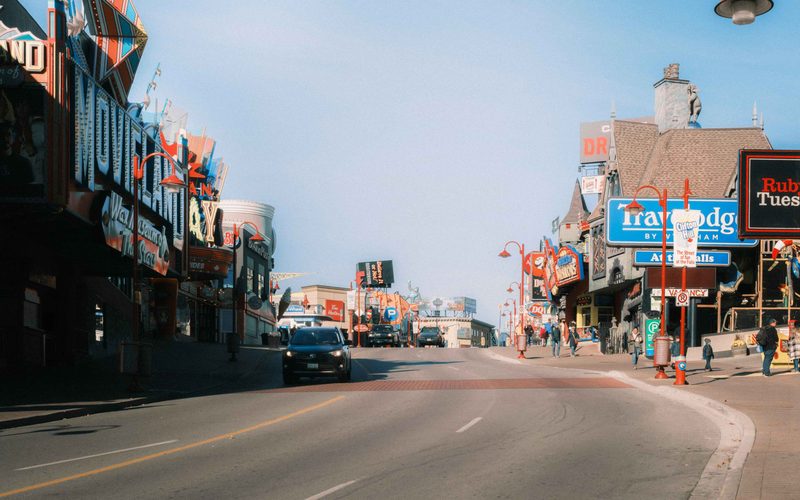 Clifton Hill in daylight, the Movieland Wax Museum and Boston Pizza frontages above the street