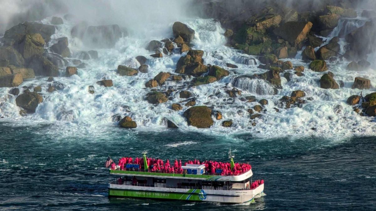 A Maid of the Mist boat below the American Falls with autumn colour on the gorge walls