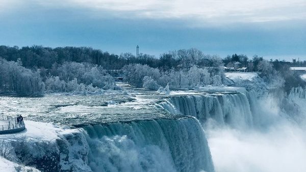 The American Falls in winter, ice along the crest and frost covered trees on the bank above the gorge