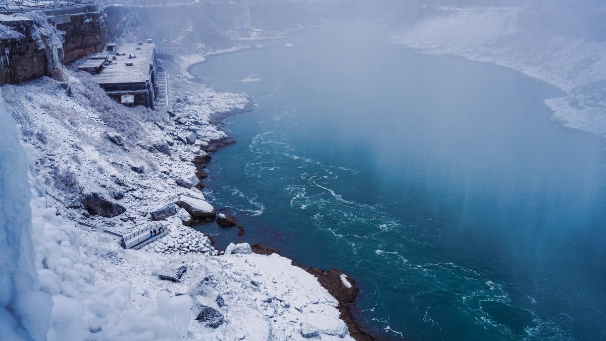 The Niagara gorge under snow and ice in winter, turquoise water running between frozen banks