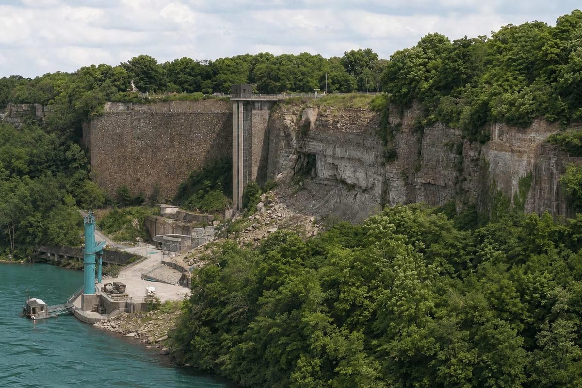 The Schoellkopf ruins today: the surviving stone retaining wall, a concrete tower and rubble at the edge of the Niagara River
