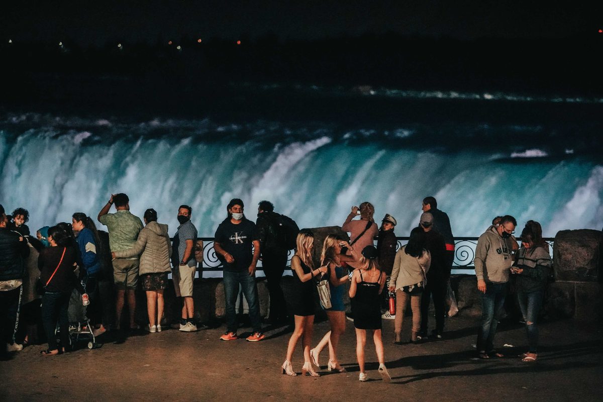 Visitors watching the illuminated falls after dark